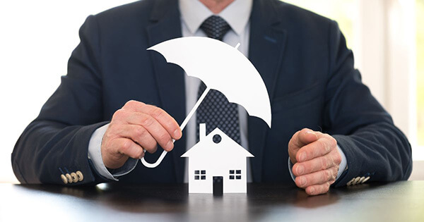 Courtier protégeant une maison avec un parapluie